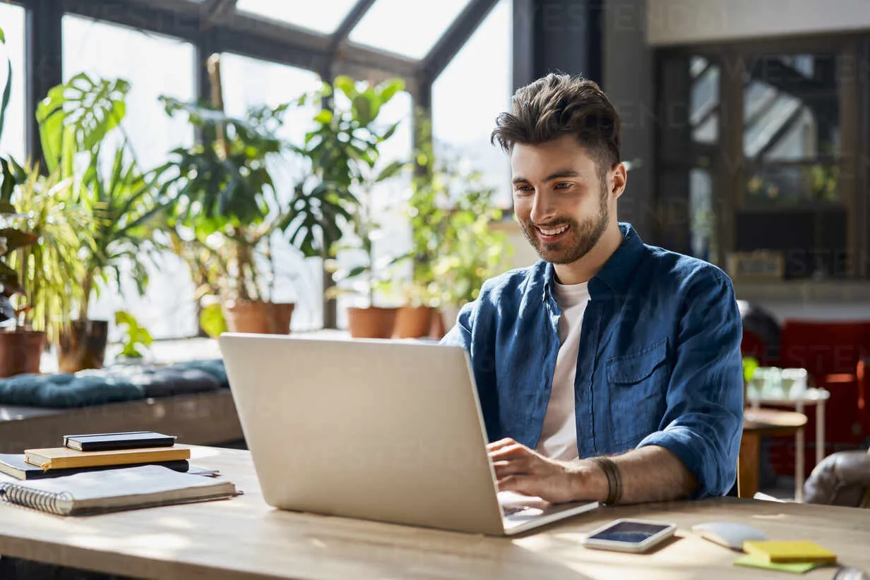 Professional smiling while working on laptop